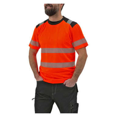 En skäggig man är klädd i en orange Bluewear kortärmad hög-vis-skjorta med silverfärgade reflekterande ränder och svarta byxor, stående med händerna i fickorna.