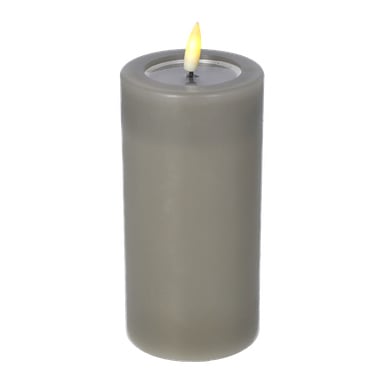 Menuett Pillar Candle med en fladdrande LED-låga är ett grått, cylindriskt ljus som står upprätt, med en tänd veke och en liten gul låga.