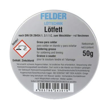 En cirkulär metallburk märkt "FELDER lödpasta" rymmer 50 g lödfett. Förpackningen visar instruktioner för lödning och tenning, en riskikon till vänster, en ingredienslista och en streckkod längst ner.