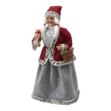 EKVIP fru Claus-figur som föreställer en glad kvinna klädd i en röd och grå juldräkt med pälsdetaljer, iförd glasögon och röd hatt, bärande en inslagen present i ena handen och en korg fylld med grönska och bär i den andra.
