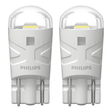 Två Philips Ultinon Pro3100 Signal-lampor visas tillsammans, var och en med en cylindrisk kropp, rundade transparenta toppar och Philips-logotypen på framsidan. Deras elektroniska kontakter är synliga längst ner.