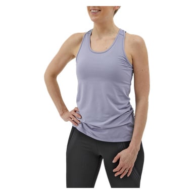 Eine Frau trägt das Kayoba Women's Training Tank Top Albany in hellem Lila mit schwarzen Leggings. Sie posiert mit einer Hand in der Hüfte und der anderen an der Seite und lächelt.