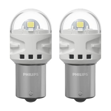 Ein Paar Philips Ultinon Pro3100 Scheinwerferlampen sind nebeneinander zu sehen, mit einer eleganten weiß-silbernen Oberfläche, abgerundeten transparenten Oberseiten und einem freiliegenden LED-Chip. Der metallische Sockel beider Lampen zeigt das Philips-Logo.