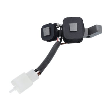 Närbild av Ignition pulse sensor-kraftverket med två svarta rektangulära plattor, en svart isolerad kabel och en vit kontakt.