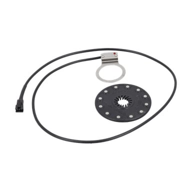 En svart cirkulär sensorskiva med magneter, en kabel och ett metallfäste, använd som pedalassistanssensor för elcyklar.
