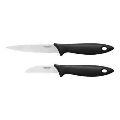 Två Fiskars Essential köksknivar ligger bredvid varandra. Den övre kniven har ett långt, spetsigt blad av rostfritt stål, medan den nedre kniven har ett kortare, böjt blad. Varje kniv är försedd med ett svart handtag som har ett hål nära spetsen.