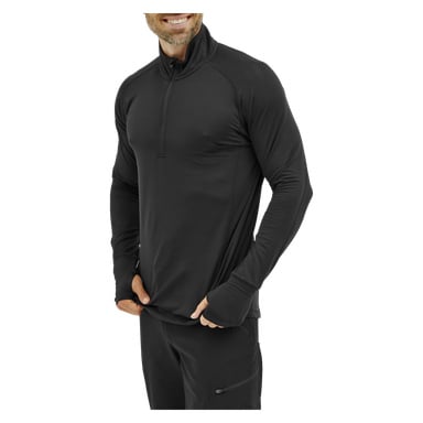 En mann, kledd i Kayoba Men's Functional Top London – en svart langermet sportsgenser med glidelåskrage og tommelhull – og svarte treningsbukser, smiler mens han holder i kanten på skjorten sin.
