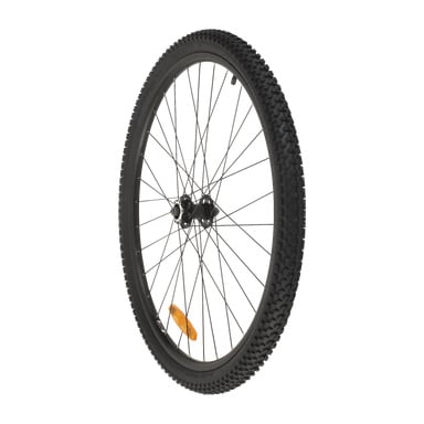 Framfälgen på mountainbiken har ett svart hjul med ett knoppigt däck, metallekrar, centralnav och en orange reflektor.