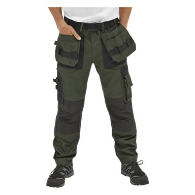 Eine Person in Bluewear Men's Arbeitshose, Mr Green, waldgrün und schwarz mit mehreren Taschen und Schlaufen, trägt ein weißes Hemd und schwarze Arbeitsschuhe. Nur die untere Körperhälfte ist zu sehen.