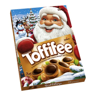 En festlig Toffifee Xmas Edition chokladask, dekorerad med julillustrationer av jultomten, en snögubbe och en ren. Förpackningen visar en bild av chokladen och har frasen "En hasselnöt i karamell med krämig nougat och choklad."