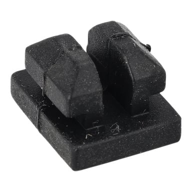 En svart, rektangulär "Rubber pads gas grill" har två vinklade upphöjda sektioner på en plan bas, med damm och fibrer på ytan.