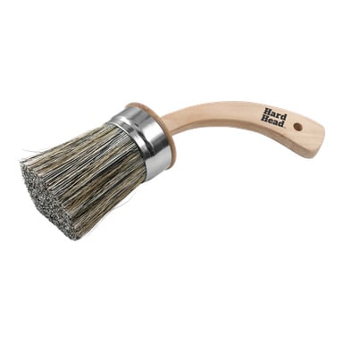 En rund pensel med böjt trähandtag, hål i änden, metallrem, tjocka borst och "Hard Head" på handtaget.