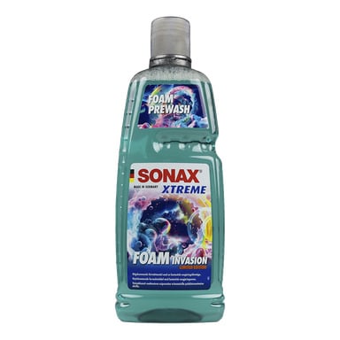 En grön flaska Sonax biltvättschampo, märkt "Xtreme Foam Invasion Limited Edition" med en grå kapsyl och färgglada tvåpbubblor på etiketten, som visar "Made in Germany" för biltvätt.