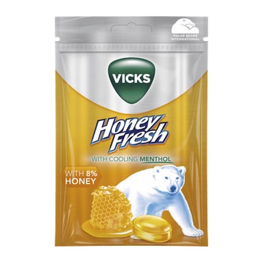 Vicks Honey Fresh pastillpakke viser en isbjørn, honningkake og pastiller foran, som fremmer kjølende mentol og 8 % honning.