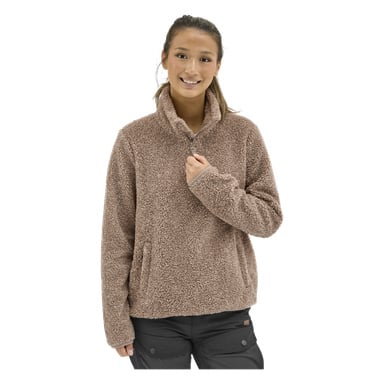 En kvinna visar Kayoba Outdoor Hamra sherpajacka i ljusbrunt med hög krage och svarta byxor, ler och håller i kragen.