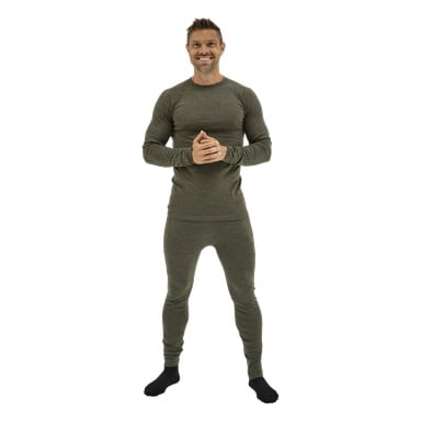 En man ler framåt, händerna knäppta, klädd i olivgrönt Kayoba Outdoor Merino ullbaslager och svarta strumpor.