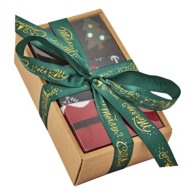 En liten brun presentförpackning med ett mörkgrönt band med texten "Merry Christmas" i guldskrift, innehållande synliga röda och svarta strumpor med festliga mönster, bl.a. en julgran.