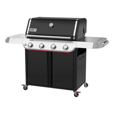 Slank svart och silverfärgad gasgrill med fyra rattar, termometer på locket, två sidohyllor, förvaring under och hjul.