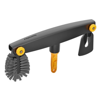 En grå och gul rengöringsborste med styva borst, brett handtag, avtagbart blad, Fiskars-logga och orange fäste på handtaget.