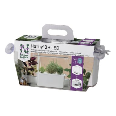 Ett Nelson Garden Harvy 3 + LED hydroponikkit i sin låda, med bilder på kitet med gröna växter, ett topphandtag och produktinformation.
