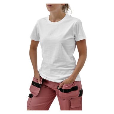 Die Person in einem weißen T-Shirt und rosa Utility-Hosen mit schwarzen Taschen steht Hände in Taschen; Bild beschnitten von Hals bis zu Oberschenkeln.