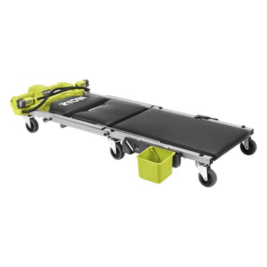 Ryobi batteridrevet mekaniker-creeper med svart polstret overflate, svingbare hjul, gul oppbevaringsboks og nærliggende batterier.