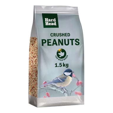En 1,5 kg påse krossade jordnötter från märket Hard Head för vilda fåglar. En blåmesa sitter på en gren framför en suddig, vintrig bakgrund.