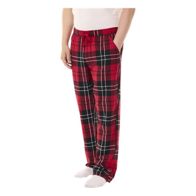 Eine Person steht mit den Händen in den Taschen, gekleidet in Bluewear Pyjama-Hosen mit rot-schwarzem Karomuster, dazu ein weißes Hemd und passende weiße Socken.