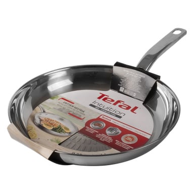 En ny Tefal Intuition rostfri stekpanna med långt handtag visas, med produktetikett och förpackning fäst inuti pannan.