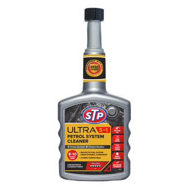 En flaske STP Petrol Additive Ultra 5-i-1 med grå kork. Etiketten fremhever rengjørings- og beskyttelsesfunksjoner, nevner kompatibilitet med E-10 bensin, og viser ikoner som representerer forbedret effekt, korrosjonsbeskyttelse, reduserte utslipp og slitasjebeskyttelse.