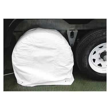 Ett Hamron Tyre Protection 1-pack täcker ett reservdäck monterat på ett fordon, bredvid ett exponerat hjul med vit fälg, allt placerat på en grön texturerad yta.