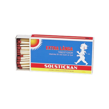 En ask Solstickan-tändstickor med extra långa, rödspetsade tändstickor inuti. Förpackningen har en färgskala i blått, vitt och rött med en illustration av ett barn som går och text på framsidan.