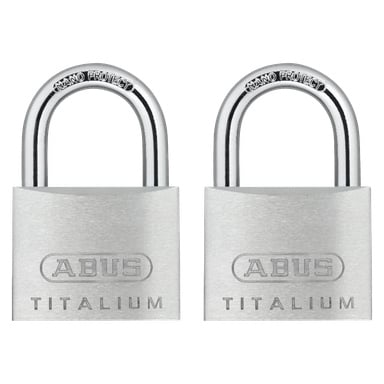 Två silverfärgade ABUS Titalium 64-hänglås är placerade bredvid varandra. Båda låsen visar "TITALIUM" längst ner och "ABUS" i mitten, med sina metallbojor märkta "NANO PROTECT."