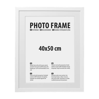 En hvit rektangulær bilderamme fra No brand EMW inneholder en innvendig etikett hvor det står "FOTORAMME" og "40x50 cm", sammen med beskrivelser av materialene og bruksanvisning.