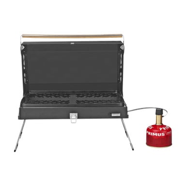 Primus Portable LPG-grillen Kuchoma syns med locket öppet, fällbara ben utfällda och en röd Primus-gasbehållare fäst.