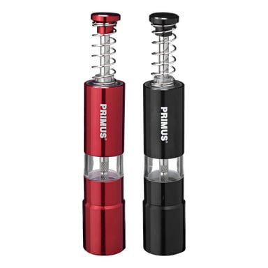 Ett par Primus-handdrivna fräsar, en röd och en svart, båda med exponerade metallfjädrar och transparenta sektioner som visar interiören. Förpackningen visar frasen "Salt and pepper mill 2 pieces" i vitt.